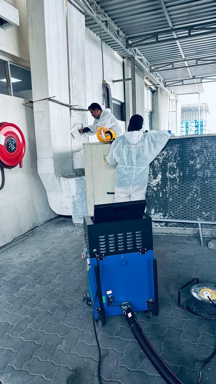 HoodEx technicians with duct-cleaning equipment working on ductwork at a commercial site